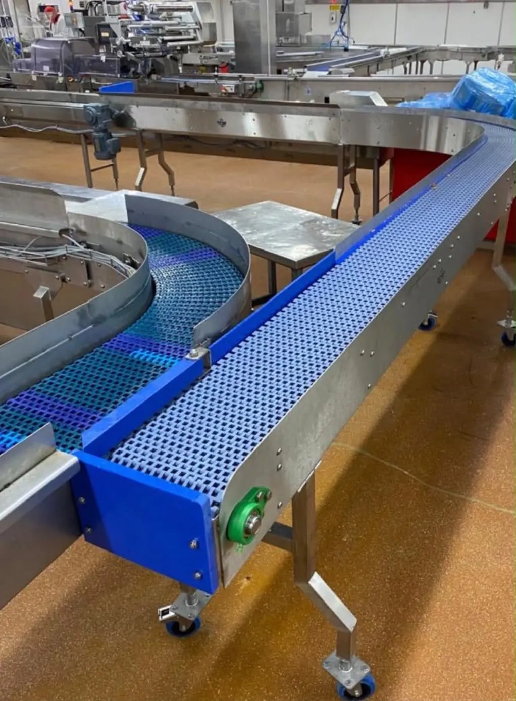 Blue modular-belt curved conveyor system manufactured for a food production line